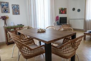 een eetkamer met een houten tafel en stoelen bij Le Vele Mondello, villa a due passi dal mare in Mondello