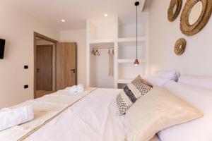 ein Schlafzimmer mit einem großen weißen Bett mit zwei Kissen in der Unterkunft Portogal Apartments in Argostoli + 18 Fotos