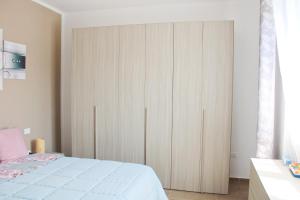 a bedroom with a large white wardrobe and a bed at Family apartment in Massa Lombarda