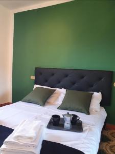 Una cama con un cabecero verde con una bandeja. en Ca' della Bardona, en La Foce