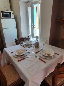una mesa con platos y copas de vino. en Ca' della Bardona, en La Foce