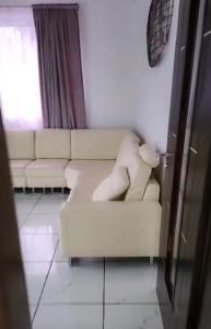 a living room with a white couch and a window at Rooftop Villa in Freetown