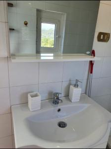 y baño con lavabo blanco y espejo. en Ca' della Bardona, en La Foce