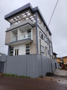 un edificio con una valla delante en Rooftop Villa en Freetown