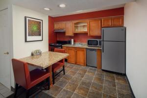 a kitchen with a table and a refrigerator at Residence Inn Binghamton in Vestal