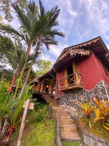 a red house with stairs leading up to it at Villa Toucan with National Geographic Views in Puerto Viejo