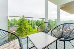 two chairs and a table on a balcony with a view at Apartament Przy Plaży - Błękitna Laguna by Perłowa Przystań Rent in Sianozety