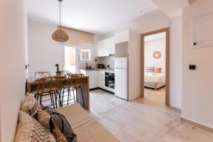 eine Küche und ein Wohnzimmer mit Tisch und Stühlen in der Unterkunft Portogal Apartments in Argostoli
