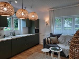 a living room with a couch and a kitchen with windows at Põlva Maja apartments - contactless check-in in Põlva