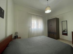 a bedroom with a bed and a dresser and a window at Evi's apartment Pefkochori in Pefkochori