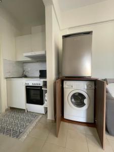 a kitchen with a washing machine and a stove at Evi's apartment Pefkochori in Pefkochori