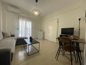 a living room with a bed and a table and a desk at Evi's apartment Pefkochori in Pefkochori
