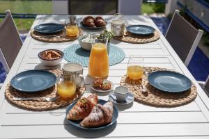 une table avec des assiettes de nourriture et des verres de jus d'orange dans l'établissement Le Vele Mondello, villa a due passi dal mare, à Mondello