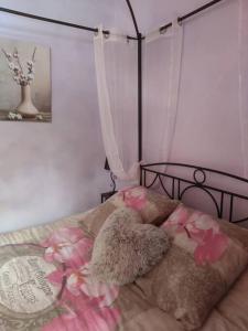 a bedroom with a bed with pink flowers on it at Sous le château in Montaut-de-Crieux