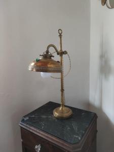 a brass lamp sitting on top of a chest at Sous le château in Montaut-de-Crieux