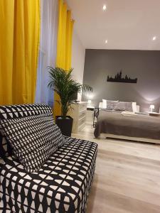 a bedroom with a large bed and yellow curtains at L-2 Kraków Center Studio O&P ApartFamily in Kraków