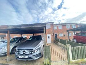 two cars parked in a parking lot in front of a house at Your Perfect Place to Relax in Havering atte Bower