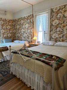 een grote slaapkamer met 2 bedden en een raam bij Gable House Bed and Breakfast Inn in Durango