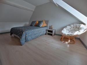 um quarto com uma cama e uma cadeira num sótão em Le palais duplex em Autun