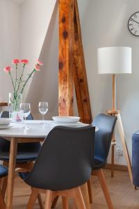 a dining room with a table and chairs and a clock at Apartament Carmen in Mikołajki
