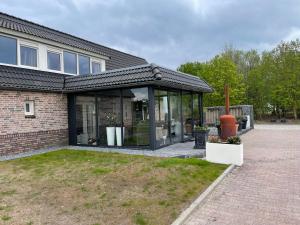 a house with a glass extension on the side of it at NextDay in Erica