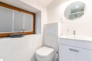 a bathroom with a toilet and a sink and a mirror at Apartament Carmen in Mikołajki