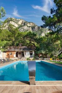 a swimming pool with a mountain in the background at Chakra Beach Kabak in Faralya