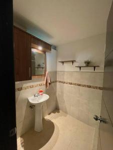 ein Badezimmer mit einem weißen Waschbecken und einem Spiegel in der Unterkunft Departamento independiente in Atuntaqui