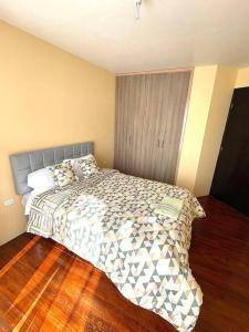 1 dormitorio con 1 cama y suelo de madera en Departamento independiente, en Atuntaqui