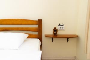 - une chambre avec un lit et une horloge sur une étagère dans l'établissement Lviv Residence І Львівська резиденція, à Lviv