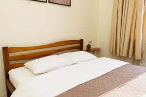 - une chambre avec 2 lits blancs et une tête de lit en bois dans l'établissement Lviv Residence І Львівська резиденція, à Lviv