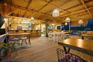 a restaurant with wooden floors and tables and chairs at Chakra Beach Kabak in Faralya