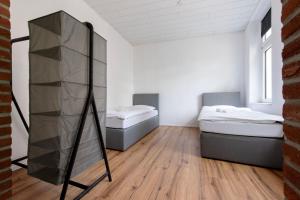 ケーヴェラアーにあるGemütliche Unterkunft direkt im Zentrum - 10 min zum Airport Weezeのベッドが2つと鏡がある部屋