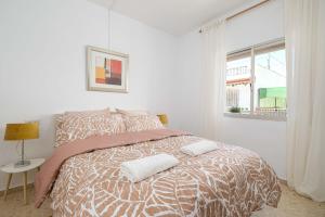a white bedroom with a bed with two pillows on it at Andalucian house, few minutes from the beach in Fuengirola