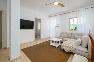 a white living room with a couch and a tv at Andalucian house, few minutes from the beach in Fuengirola