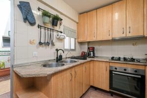 a kitchen with wooden cabinets and a sink at Andalucian house, few minutes from the beach in Fuengirola