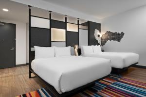 A bed or beds in a room at Aloft Kansas City Country Club Plaza