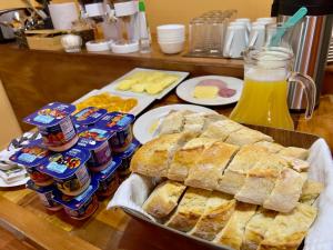 Hostal Qachi Chentura في سان بيدرو دي أتاكاما: طاولة مع صينية من الخبز وزجاجات من المشروبات الغازية