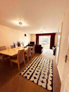 a dining room with a table and chairs and a living room at 5 STAR LUXURY BIG HOUSE, JACUZZI SPA HOT TUB, PARKING, LIVERPOOL CITY CENTRE, SLEEPS 10, EASY LOCK BoX ENTRY! NO PARTIES! in Liverpool