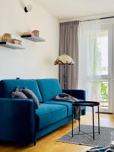 a blue couch in a living room with a table at Apartament przy Rynku in Olsztynek