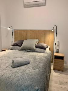 um quarto com uma cama grande e uma cabeceira em madeira em Fűzliget2-Mistral Garden em Balatonfuzfo