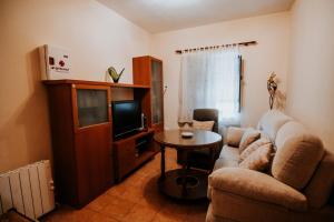 sala de estar con sofá, TV y mesa en Conde de la Encina 16 en Trujillo