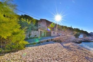 una casa en la orilla de una playa rocosa en Apartments Stokic, en Donja Klada