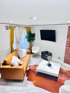 a living room with a couch and a tv at Modern Brownstone 2bdrm Duplex with Backyard terrace in Brooklyn