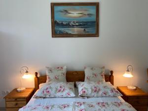 ein Schlafzimmer mit einem Bett mit zwei Lampen und einem Bild an der Wand in der Unterkunft Villa Rosa Centre in Balatonfüred