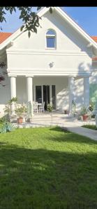 ein weißes Haus mit Rasen davor in der Unterkunft Villa Rosa Centre in Balatonfüred