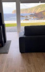 a living room with a couch and a view of the ocean at Serenity Villa - Azorean Butler in Mosteiros