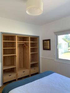 a bedroom with a bed and shelves and a window at Serenity Villa - Azorean Butler in Mosteiros