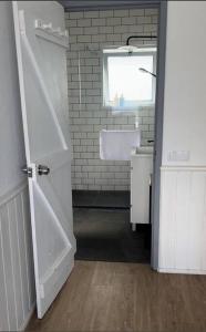 a bathroom with a sink and a white door at Serenity Villa - Azorean Butler in Mosteiros