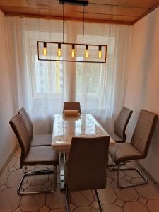 ein Esszimmer mit einem Tisch, Stühlen und einem Fenster in der Unterkunft Maria Apartment in Wolfsburg